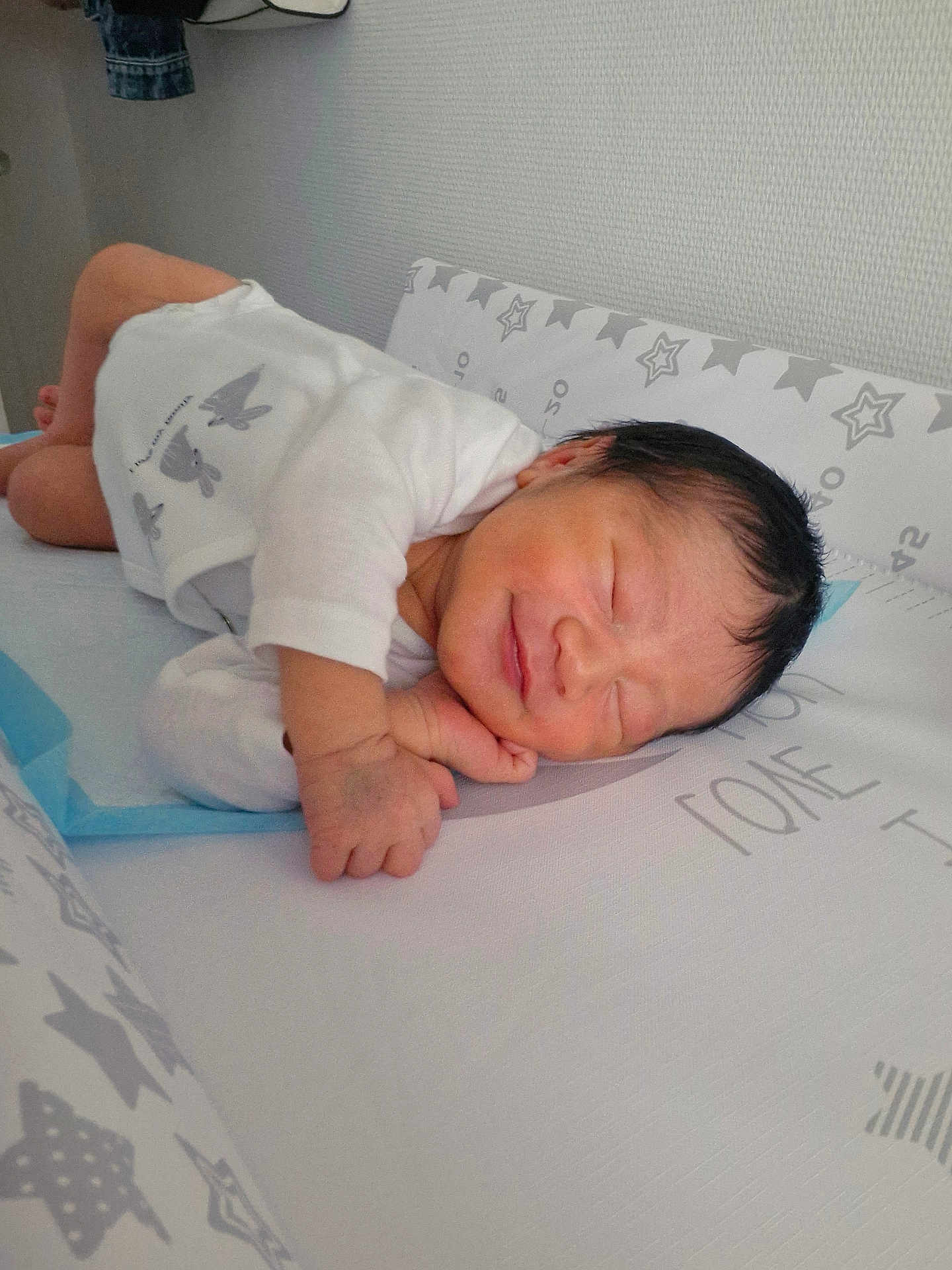 Axel participe au concours pour gagner de l'argent avec cette photo : newborn, baby, sleeping, infant, white_onesie, bunny_prints, mattress, star_pattern, soft_surface, peaceful, smile, face, hand, cute, indoors, child, portrait, resting, tiny, cozy
