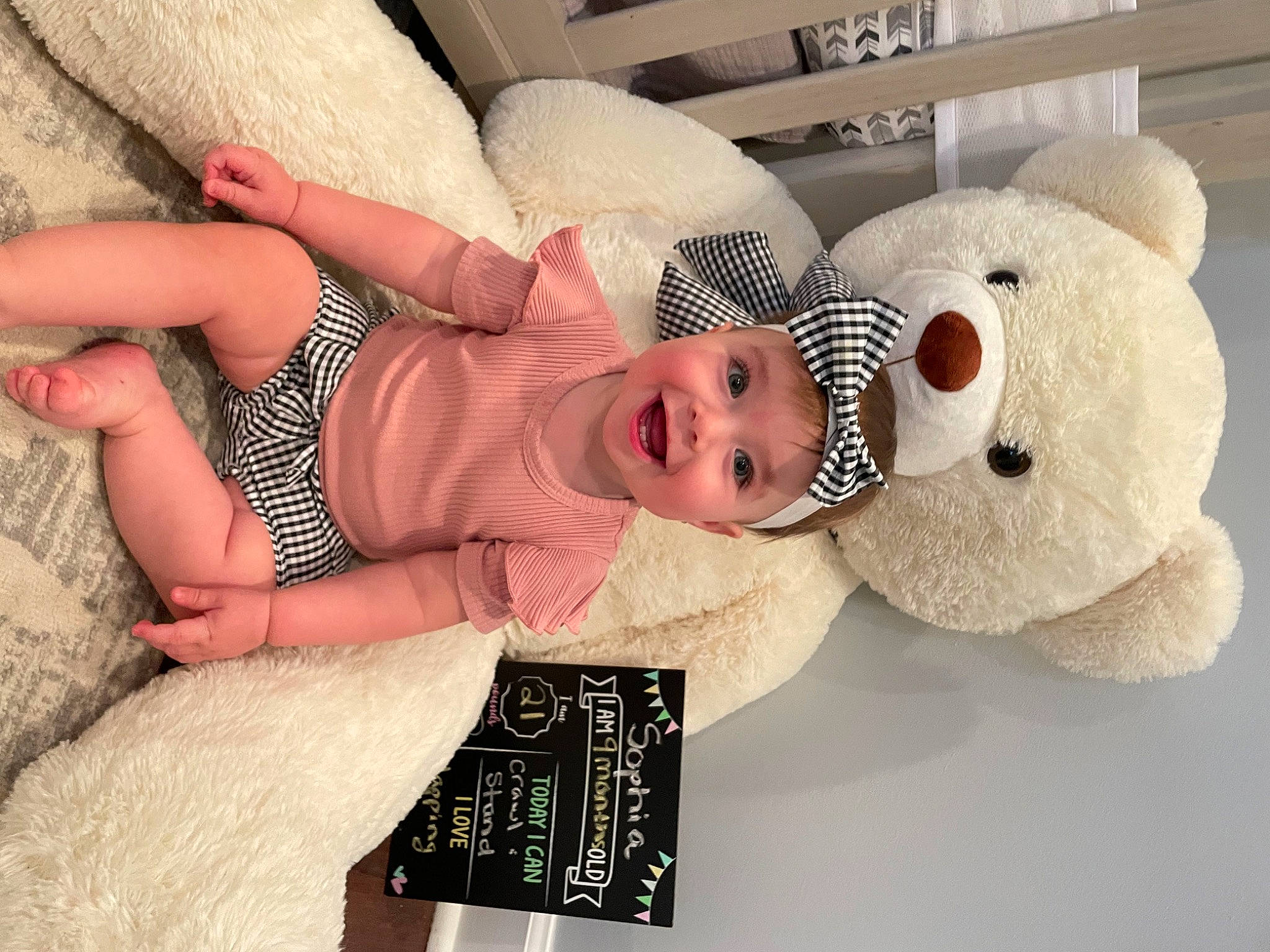 Sophia is registered to the contest to win money with this photo: baby, baby_sleeping, baby_toddler_clothing, child, comfort, facial_expression, fashion_accessory, flooring, happy, hat, head, headgear, headwear, joy, person, room, skin, smile, stuffed_toy, teddy_bear