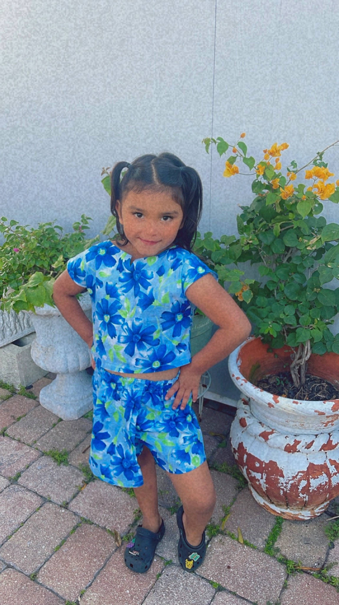 Anaya is registered to the contest to win money with this photo: baby_toddler_clothing, child, electric_blue, flower, flowerpot, garden, grass, hair, happy, houseplant, human_leg, joy, leg, leisure, person, plant, sandal, shoe, sitting, slipper