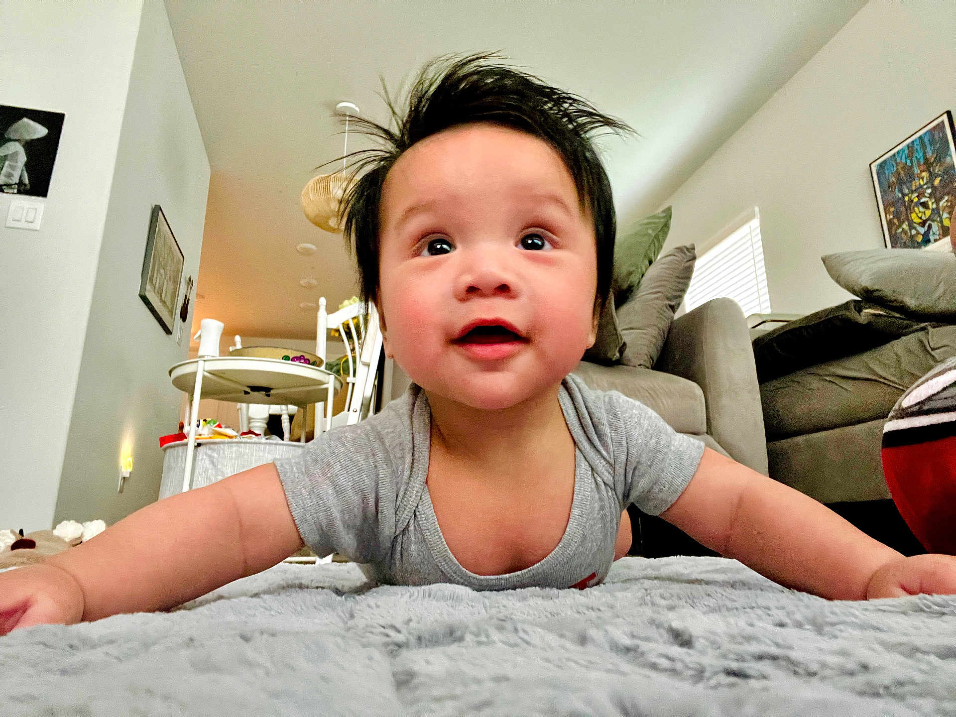 Aieden joined the competition — help win amazing prizes! baby, child, indoor, carpet, blanket, living_room, couch, pillow, table, chair, person, cute, happy, smiling, infant, toddler, home, furniture, portrait, casual