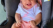 Arizona is registered to the contest to win money with this photo: baby, child, infant, smiling, happy, portrait, stroller, car_seat, safety_harness, buckle, pink_clothing, shirt, shorts, bare_feet, hands, legs, outdoor, close_up, vehicle, photography