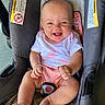 baby, child, infant, smiling, happy, portrait, stroller, car_seat, safety_harness, buckle, pink_clothing, shirt, shorts, bare_feet, hands, legs, outdoor, close_up, vehicle, photography