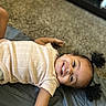 Ryyah joined the competition — help win amazing prizes! child, toddler, girl, smiling, happy, portrait, curly_hair, teeth, lying_down, indoor, carpet, blanket, bed, clothing, shirt, diaper, arm, face, home, photography