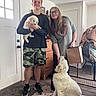 June joined the competition — help win amazing prizes! young_man, woman, puppy, dog, indoor, door, rug, carpet, furniture, pet_gate, casual_clothing, smile, glasses, holding, interaction, light, home, floor, paw_prints, happy