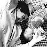 James participe au concours pour gagner de l'argent avec cette photo : black_and_white, baby, adult, smiling, face_to_face, striped_clothing, checkered_mat, joy, love, hands, playful, portrait, closeup, family, togetherness, happy, candid, indoor, casual_clothing, interaction