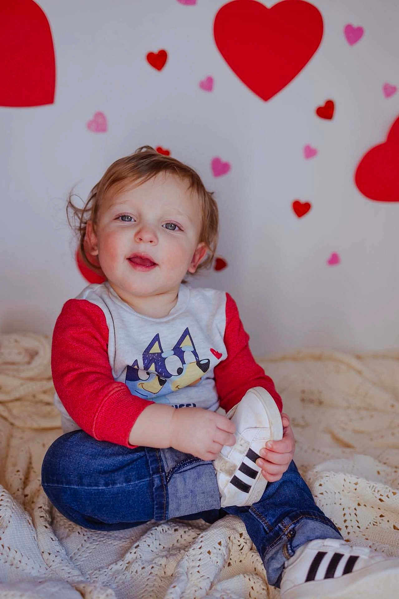 Rowan joined the competition — help win amazing prizes! child, toddler, baby, heart, hearts, valentine, portrait, sitting, shoe, sneaker, jeans, sweater, red_sleeves, blanket, cozy, cute, indoor, portrait_photography, face, smile