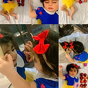 Elia is registered to the contest to win money with this photo: child, toddler, girl, snow_white_costume, blue_dress, yellow_skirt, red_bow, apples, bed, bedding, portrait, collage, mirror_selfie, sleeping, indoors, smiling, curly_hair, hair_accessory, toy, family_photo