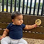 baby, child, bench, outdoor, wood, fence, giraffe, sign, clothing, pants, socks, person, cute, sitting, nature, infant, portrait, curious, casual, daytime