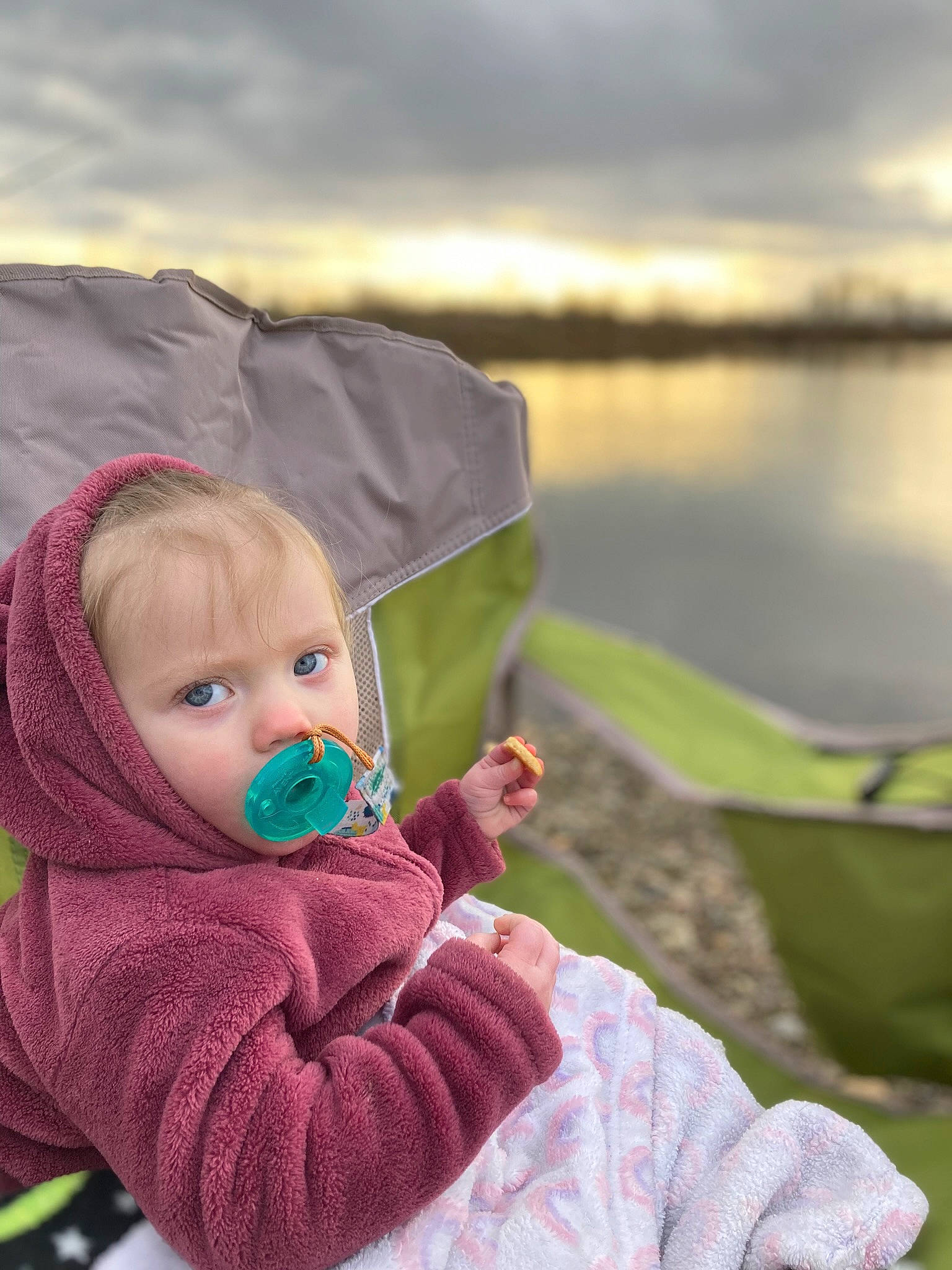 Coraline is registered to the contest to win money with this photo: baby, baby_toddler_clothing, child, cloud, comfort, fun, grass, happy, lake, lake_district, landscape, leisure, people_in_nature, person, personal_protective_equipment, recreation, sitting, sky, toddler, water