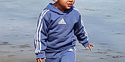Neiko is registered to the contest to win money with this photo: toddler, child, boy, outdoors, frozen_pond, barefoot, blue_tracksuit, adidas, curly_hair, winter, nature, grass, leaves, walking, exploring, young_child, casual_clothing, cold_weather, forest, daytime