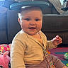 baby, child, smiling, indoor, playmat, cardigan, toy, blue_eyes, face, person, sitting, foam_ring, colorful, home, couch, happy, cute, infant, play, pacifier_clip
