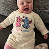 Hazel is registered to the contest to win money with this photo: baby, infant, smiling, sweater, headband, pink, blue, cartoon, character, blanket, cushion, cozy, happy, child, cute, portrait, indoors, clothing, fabric, texture