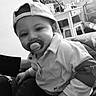 Noham a rejoint le concours — aidez-le/la à gagner de superbes lots ! baby, backwards_cap, black_and_white, blanket, cap, chair, couch, cute, face, hand, indoor, living_room, pacifier, portrait, shirt, sitting, smile, table, toddler, toy