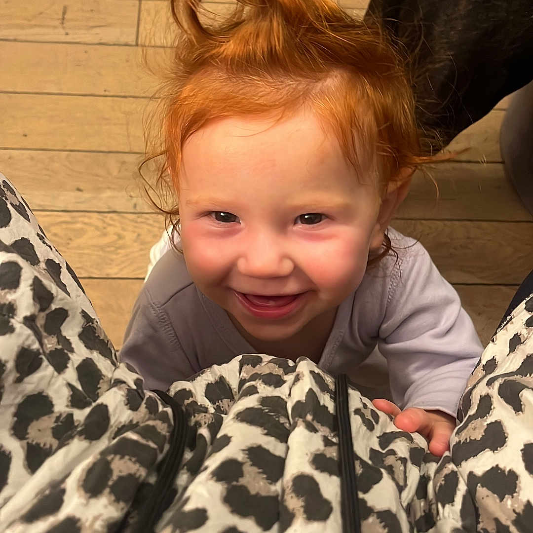 Ethel a rejoint le concours — aidez-le/la à gagner de superbes lots ! child, clothing, cute, dog, face, hair_tie, hand, happy, indoor, leopard_print, looking_up, person, pet, playful, portrait, red_hair, smile, toddler, wood_floor, young_child