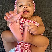 Keemani joined the competition — help win amazing prizes! baby, child, smiling, happy, headband, striped_clothing, diaper, feet, hands, playful, infant, person, cute, lying_down, carpet, indoors, skin, closeup, portrait, joyful