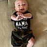 baby, child, smiling, black_shirt, camo_shorts, socks, lying_down, beige_background, happy, infant, cute, face, hands, feet, clothing, portrait, indoors, playful, young_child, person