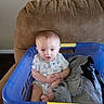 baby, laundry_basket, clothing, couch, indoor, child, onesie, furniture, blue, brown, person, sitting, curious, infant, home, soft_furniture, cute, small_child, portrait, casual
