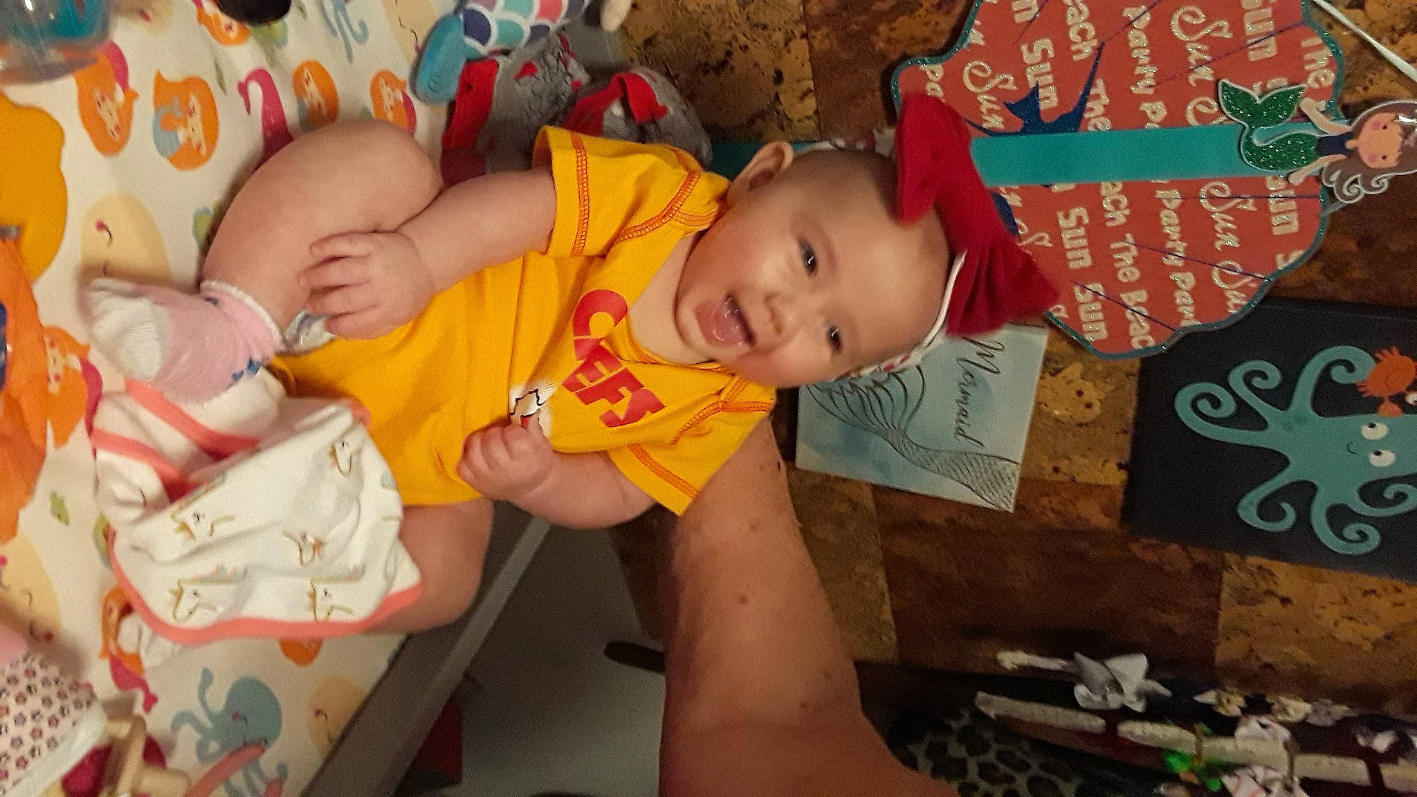 Kaydee is registered to the contest to win money with this photo: baby, baby_products, baby_toddler_clothing, cheek, child, chin, comfort, eye, finger, fun, happy, iris, mouth, nose, orange, person, sitting, skin, smile, textile