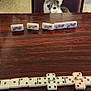 cat, chair, table, dominoes, domino_tiles, budweiser, curious, pet, indoor, game, wooden_table, domino_game, animal, board_game, sitting, looking, feline, domino_line, brown, white