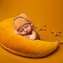 baby, sleeping, hat, pillow, yellow, mustard, star, knit, cozy, soft, newborn, resting, child, cute, portrait, indoor, warm_colors, peaceful, background, blanket