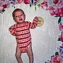 baby, infant, onesie, striped_clothing, heart_pattern, blanket, floral_border, wooden_plaque, one_month, newborn, lying_down, expression, cute, soft_texture, pink, red, white, skin, small_hands, small_feet