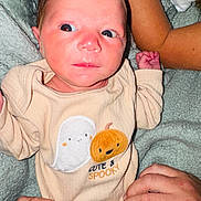 Lilah joined the competition — help win amazing prizes! baby, infant, onesie, cute, spooky, ghost, pumpkin, clothing, hands, blanket, person, child, portrait, skin, face, expression, cozy, soft, indoor, newborn