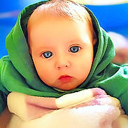 Ellipsis joined the competition — help win amazing prizes! baby, blanket, blue_eyes, cheeks, child, closeup, colorful_background, cozy, expression, eyes, face, gaze, green_hoodie, hood, indoors, infant, portrait, skin, soft_texture, warm_lighting