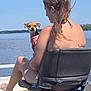 Koko joined the competition — help win amazing prizes! woman, dog, boat, water, outdoor, sky, summer, pet, animal, seated, harness, nature, relaxing, back_view, hair, blue_sky, body_of_water, vacation, sunlight, casual