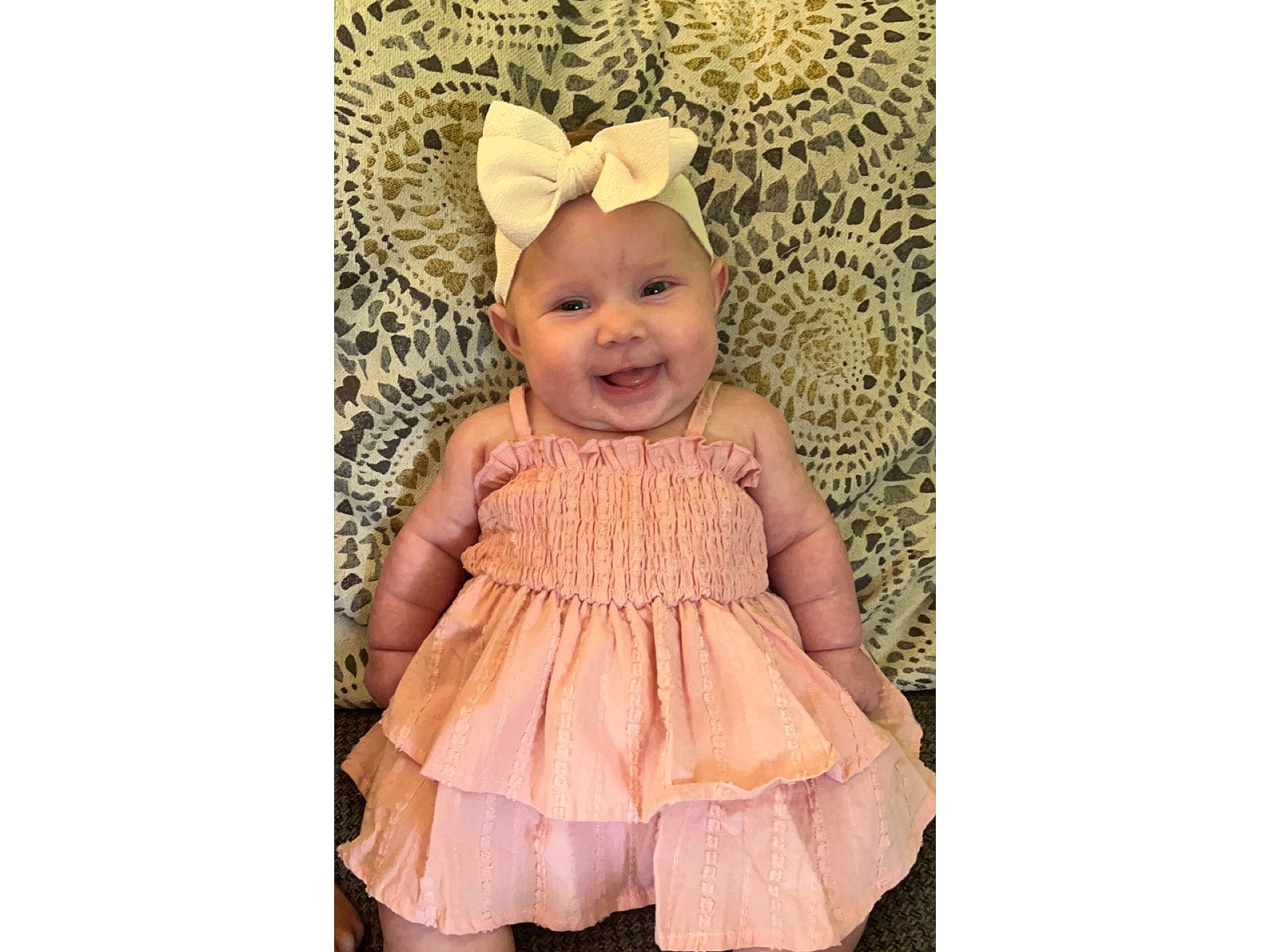 Ailani is registered to the contest to win money with this photo: baby, baby_toddler_clothing, child, clothing, day_dress, dress, embellishment, hair_accessory, happy, headpiece, headwear, joy, linens, magenta, pattern, peach, person, pink, ruffle, skin