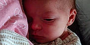Aliyah is registered to the contest to win money with this photo: baby, blanket, clothing, face, infant, newborn, person, portrait, sleepy, soft, snuggled, warm, young_child, indoors, cozy, pink, patterned_clothing, head, closeup, resting