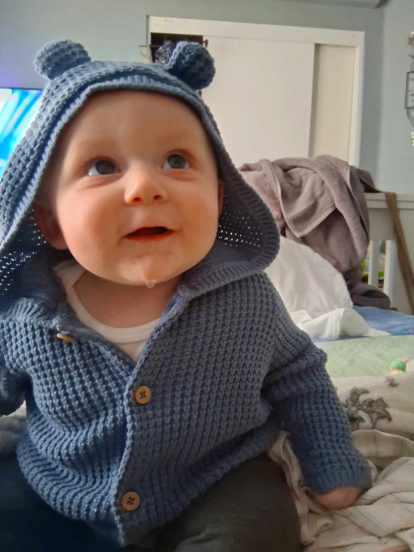 Oliver joined the competition — help win amazing prizes! baby, child, infant, smile, open_mouth, drool, knit_hood, blue_sweater, buttons, hood, eyes_up, sitting, bedroom, blanket, cozy, portrait, indoor, cute, adorable, face