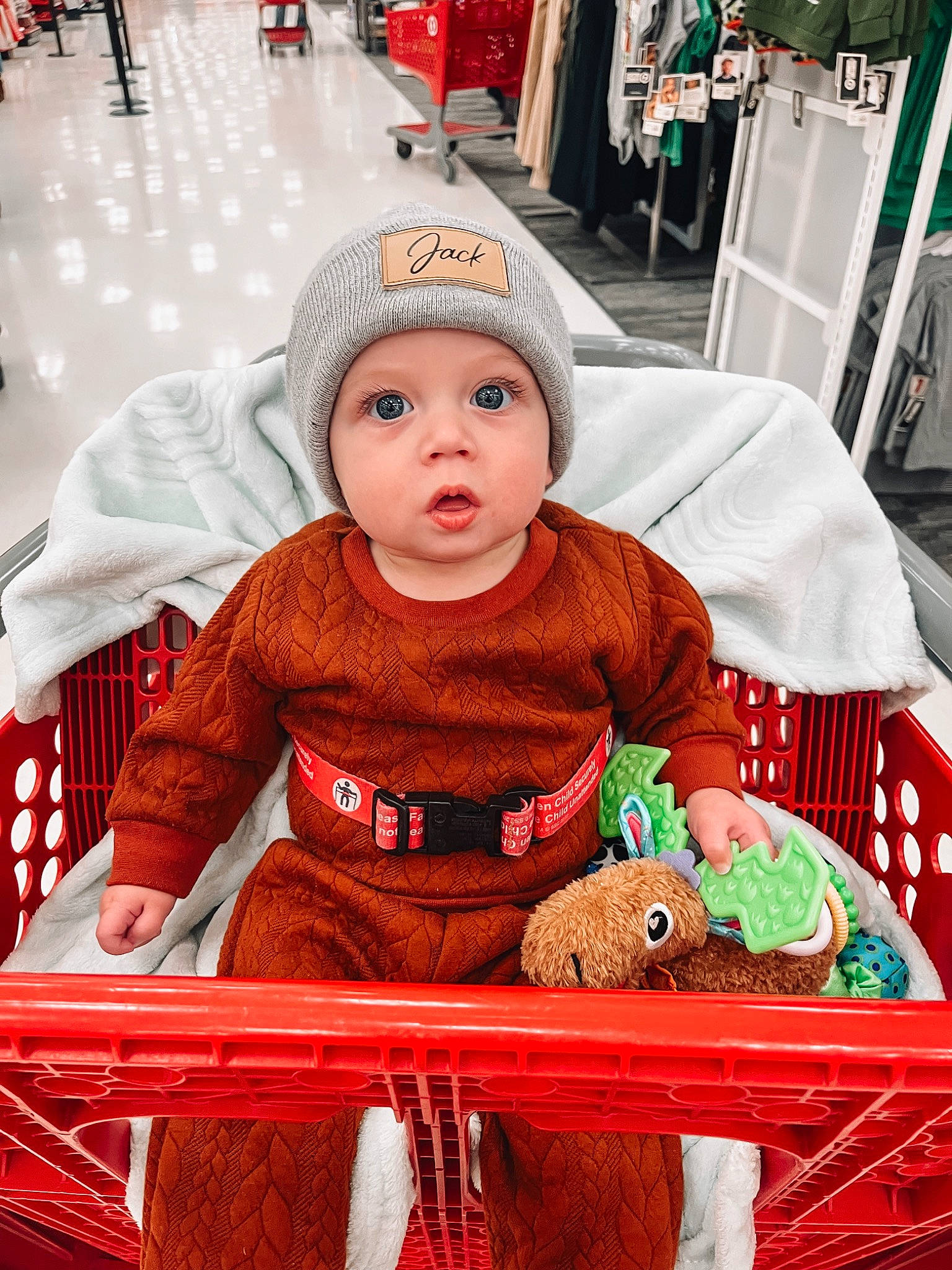 Jack joined the competition — help win amazing prizes! baby, baby_toddler_clothing, beanie, cap, child, city, event, fun, green, happy, headwear, holiday, hoodie, knit_cap, pattern, person, red, retail, shopping, sitting