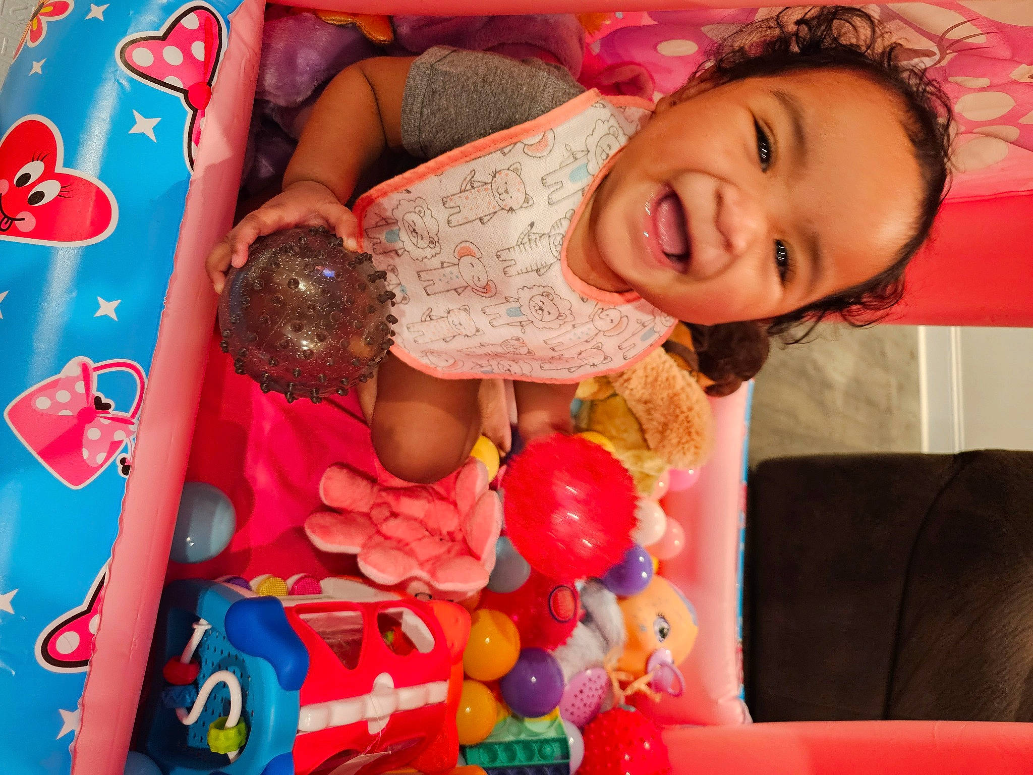 Nevaeh Mae is registered to the contest to win money with this photo: abdomen, child, couch, dress, event, eyelash, fun, happy, human_leg, magenta, nail, party_supply, pattern, person, pink, red, room, smile, sweetness, thigh