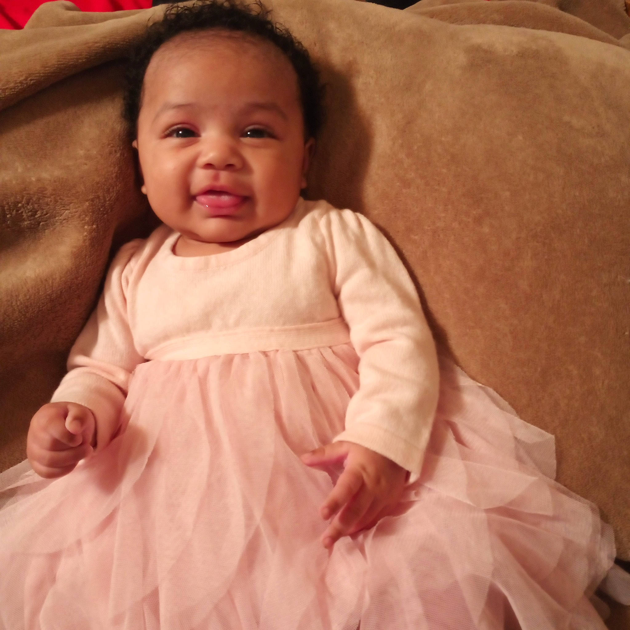 Amani joined the competition — help win amazing prizes! baby_toddler_clothing, cheek, chin, comfort, day_dress, face, finger, gesture, happy, head, neck, one_piece_garment, person, pink, product, skin, sleeve, smile, standing, textile