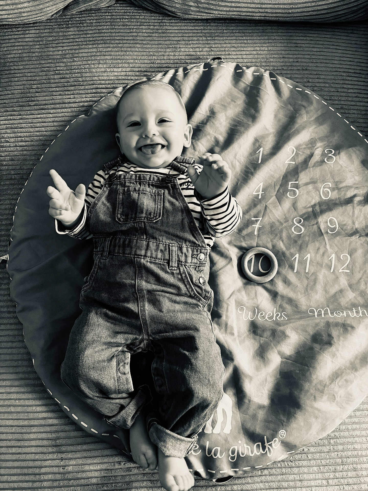 Ayden participe au concours pour gagner de l'argent avec cette photo : baby, infant, smiling, tongue_out, overalls, striped_shirt, play_mat, milestone_blanket, numbers, months, weeks, toy_ring, denim, lying_down, monochrome, portrait, happy, cute, hands, feet