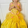 child, clothing, costume, cute, door, fashion, floor, girl, gold_designs, happy, indoor, person, pink_flowers, playful, portrait, princess, smiling, standing, yellow_dress, young