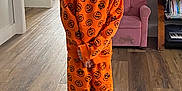 Lillian joined the competition — help win amazing prizes! casual, child, cozy, cute, flooring, furniture, happy, home, indoor, living_room, orange_clothing, pajamas, person, pink_armchair, portrait, pumpkin_pattern, smiling, socks, television, wooden_floor