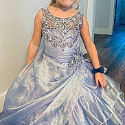 Lillian is registered to the contest to win money with this photo: child, girl, dress, silver_dress, indoor, floor, smile, pose, watch, long_dress, blonde_hair, person, happy, home, shiny, flooring, wall, room, casual, portrait