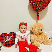 Nova is registered to the contest to win money with this photo: baby, bare_feet, blanket, child, cute, heart_box, holiday, indoor, infant, long_sleeve, photography, red_bow, red_pants, sitting, smile, teddy_bear, toy, valentine_balloon, valentines_outfit, white_wall