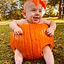 Nova is registered to the contest to win money with this photo: baby, pumpkin, orange_bow, smiling, drooling, outdoor, grass, autumn_leaves, trees, headband, cute, child, nature, fall, seasonal, happy, barefoot, greenery, sunlight, portrait