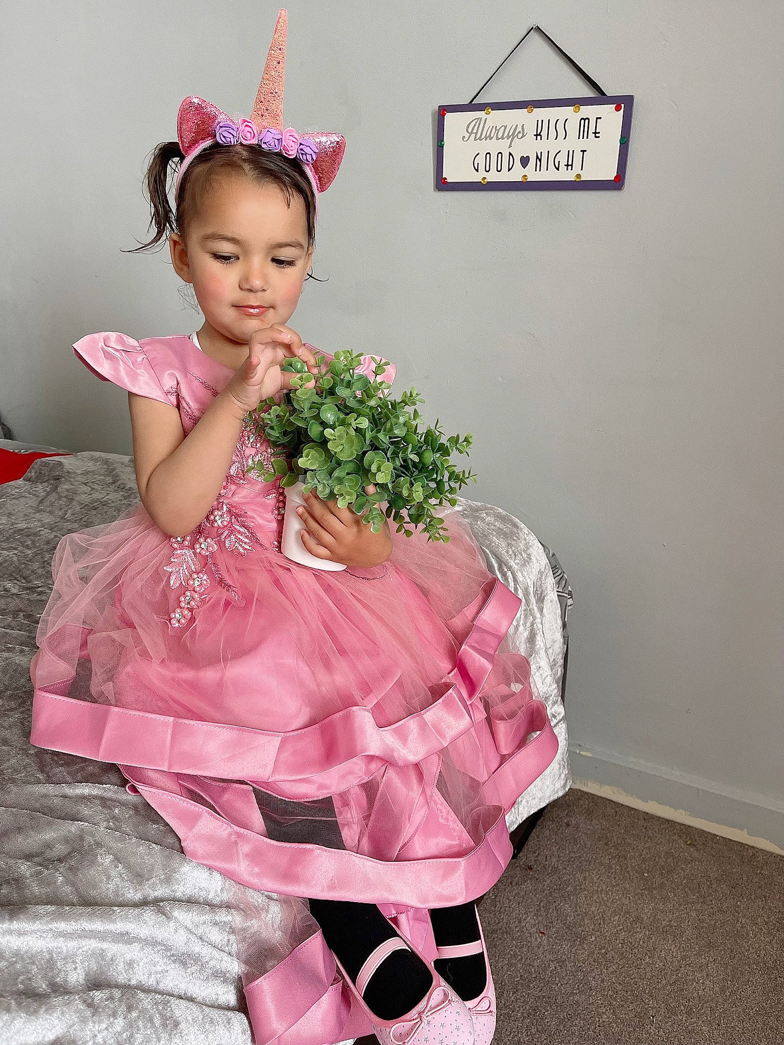 Elisa is registered to the contest to win money with this photo: baby_toddler_clothing, day_dress, dress, embellishment, event, fashion_design, hair_accessory, hairstyle, happy, hat, headband, headgear, headpiece, human_body, jewellery, magenta, person, pink, plant, ruffle