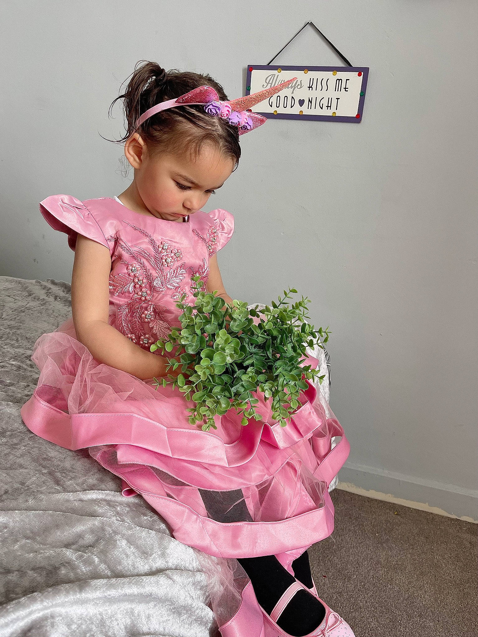Elisa is registered to the contest to win money with this photo: baby_toddler_clothing, child, day_dress, dress, embellishment, event, fashion_accessory, fashion_design, flower, flower_arranging, happy, headpiece, magenta, pattern, person, petal, pink, plant, sleeve, textile