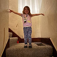 Madison joined the competition — help win amazing prizes! child, girl, smile, standing, stairs, carpet, tshirt, minnie_mouse, patterned_pants, arms_outstretched, indoors, wall, lighting, happy, person, footwear, home, room, young, casual_clothing