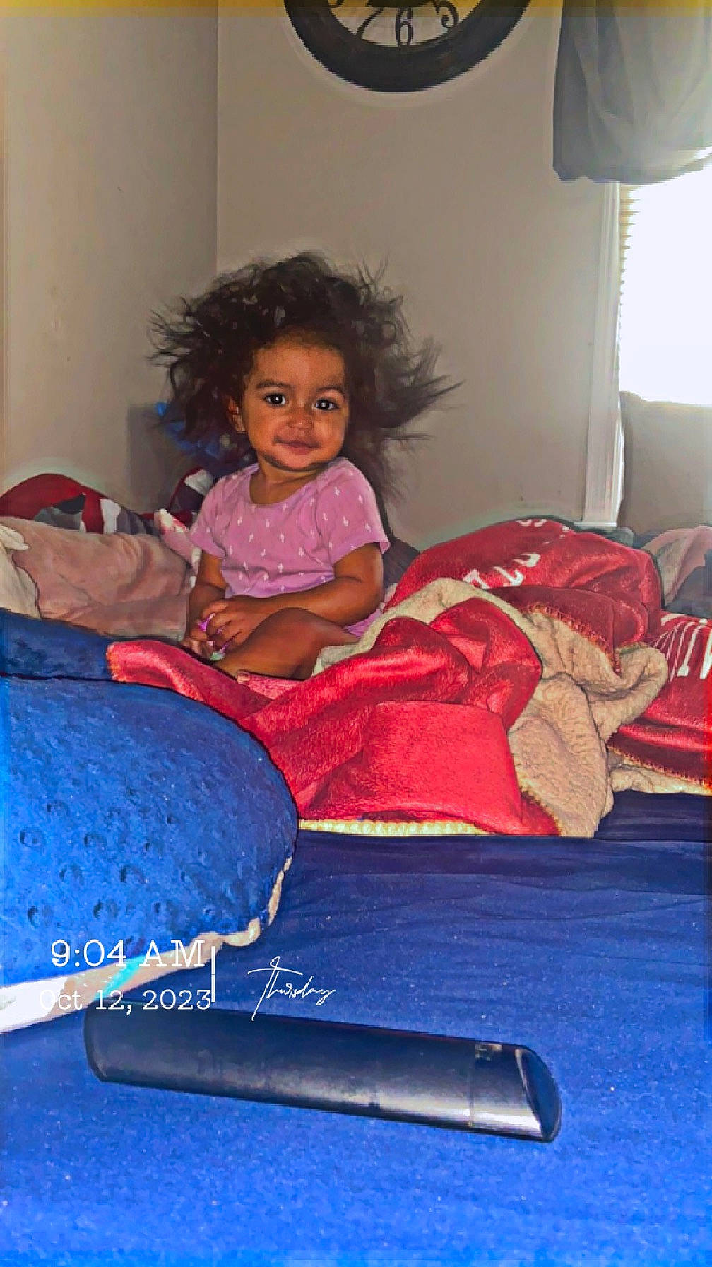 Danna is registered to the contest to win money with this photo: child, comfort, electric_blue, flooring, fun, lamp, lap, leisure, linens, living_room, magenta, mechanical_fan, person, play, purple, room, sitting, smile, toddler
