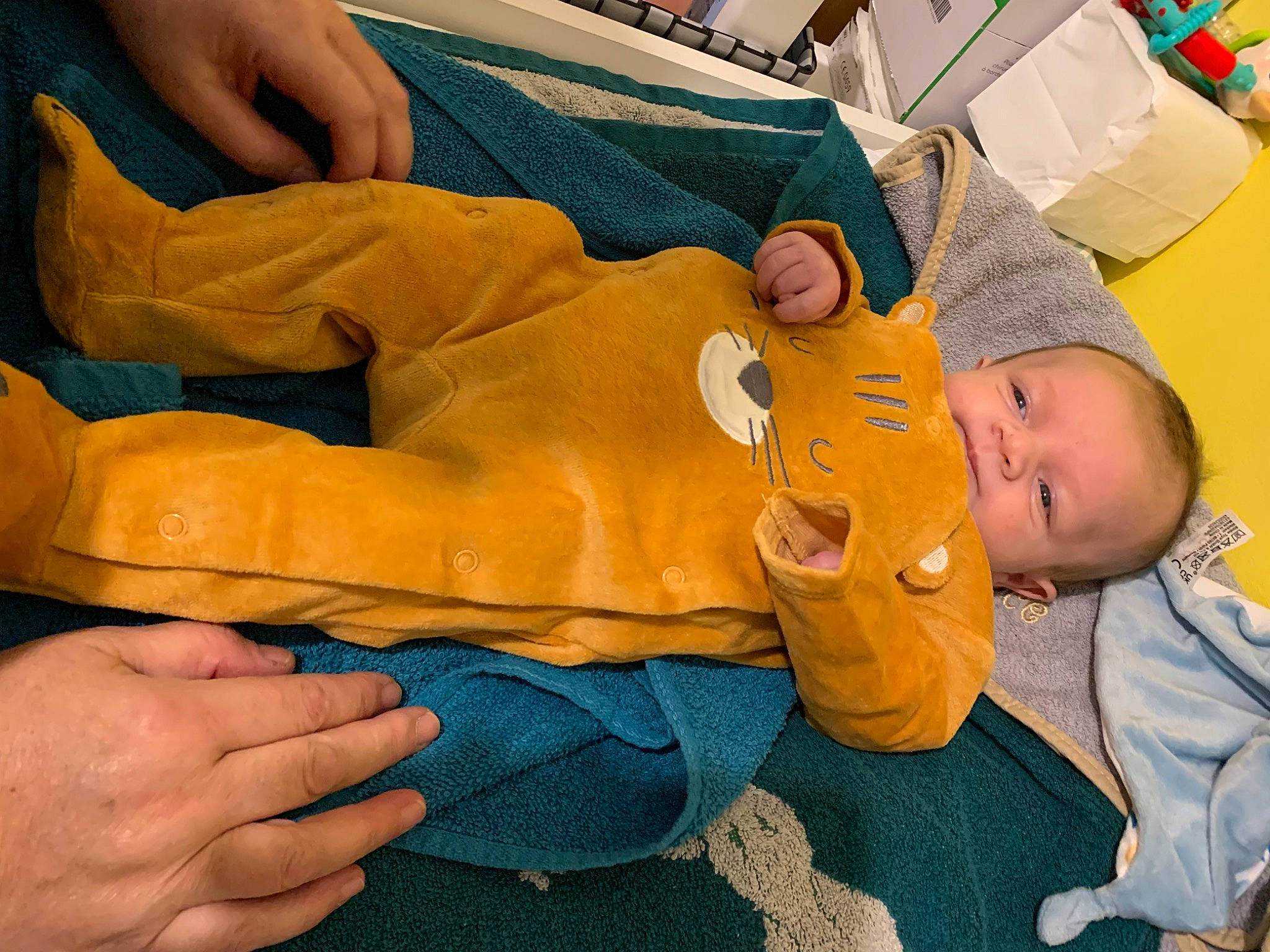 émile participe au concours pour gagner de l'argent avec cette photo : abdomen, baby, chest, comfort, elbow, electric_blue, finger, fun, gesture, hand, human_leg, knee, linens, nail, person, room, sitting, thumb, toddler, wood