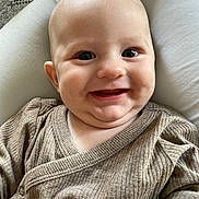 Maël participe au concours pour gagner de l'argent avec cette photo : baby, child, closeup, clothing, cozy, cushion, cute, eyes, face, happy, head, human, indoors, infant, person, portrait, skin, smile, sweater, warm