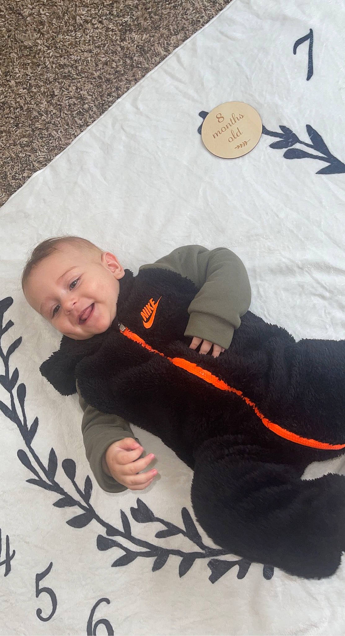 Julian is registered to the contest to win money with this photo: baby, baby_toddler_clothing, child, comfort, flooring, font, fun, grass, happy, knee, linens, person, room, sitting, sleeve, smile, t_shirt, textile, toddler, tree