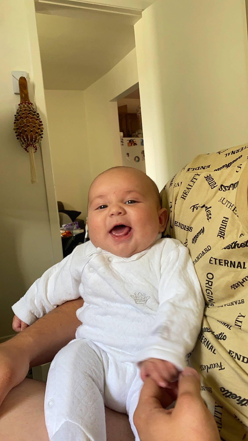 Massimo a rejoint le concours — aidez-le/la à gagner de superbes lots ! baby, baby_toddler_clothing, child, comfort, couch, facial_expression, floor, flooring, happy, linens, pattern, person, product, room, sitting, skin, sleeve, smile, t_shirt, textile