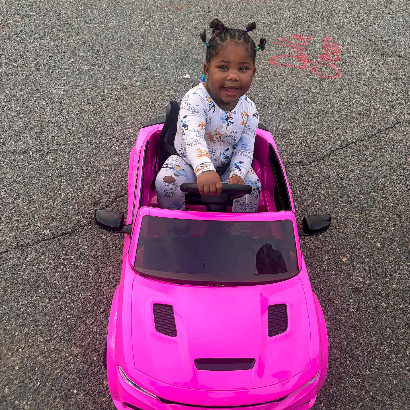 Nykajiah joined the competition — help win amazing prizes! toddler, child, toy_car, pink_car, outdoor, asphalt, smiling, happy, playtime, cute, person, vehicle, daylight, hair_buns, colorful_hair, pajamas, fun, small_car, young_child, joyful