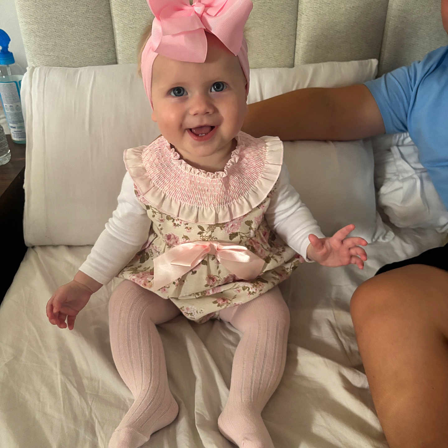 Darla-Marie joined the competition — help win amazing prizes! arm, baby, bed, child, cushion, cute, fabric, floral_dress, happy, headband, human, indoors, infant, person, pillow, pink_bow, portrait, sitting, smile, tights
